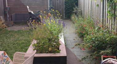 Stadstuin met bloeiende bloemen, fietsen en houten omheining