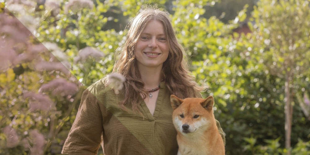 Psycholoog en hovenier Esmee Hutten poseert met hond in tuin