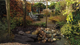 Tuin met stoelen, tafel, planten en grind, ingericht als buitenruimte