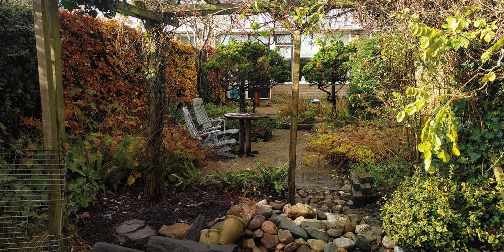 Tuin met stoelen, tafel, planten en grind, ingericht als buitenruimte