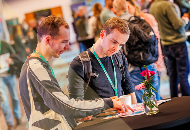 Mensen bekijken brochure tijdens Congres Natuurlijk!
